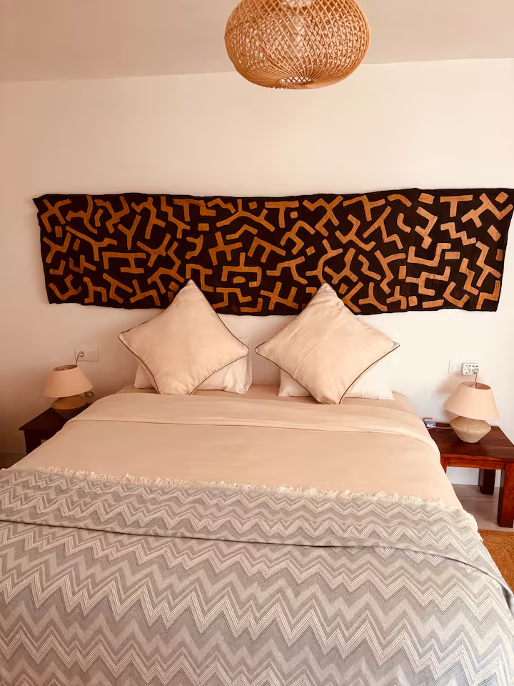 Bedroom with woven pendant light and textile wall art