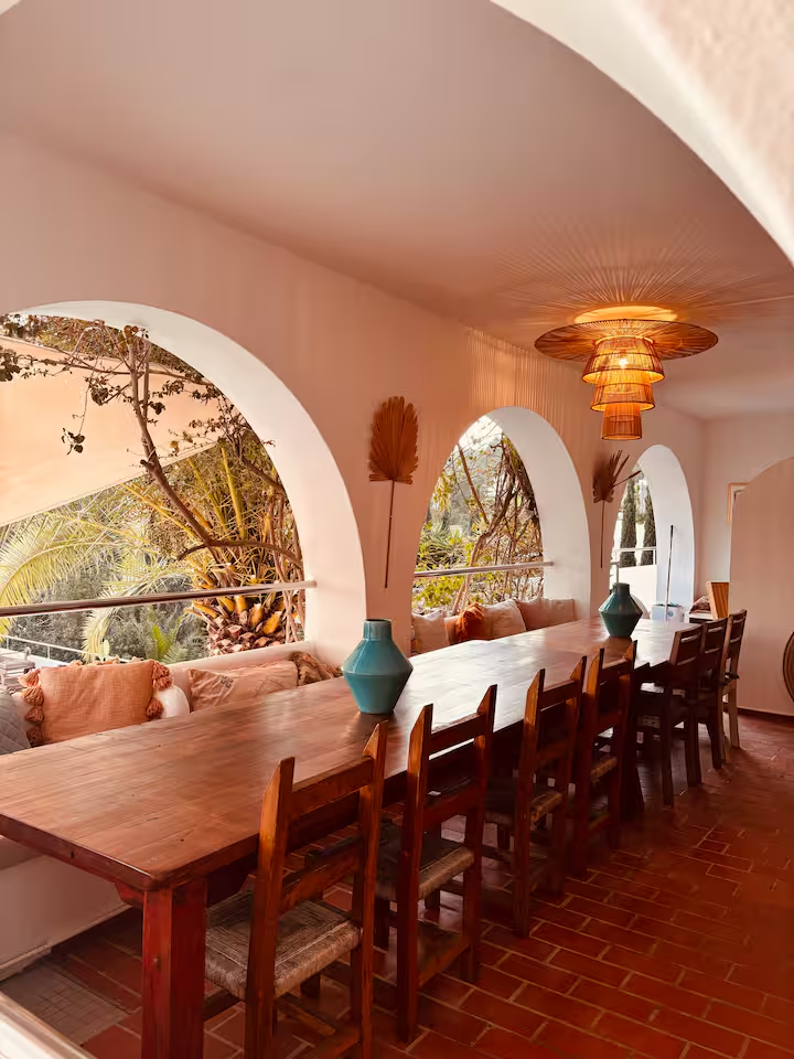 Arched terrace dining room with long wooden table